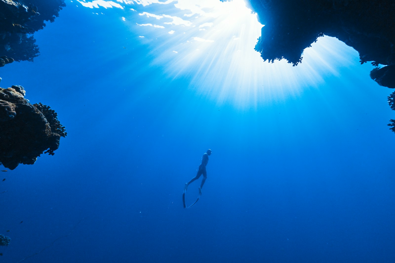 une personne nageant dans l'océan près d'une grotte